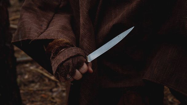 Hand gripping knife in a threatening manner - Zdjęcie, obraz