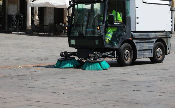 furgoneta pequeña para limpiar la plaza de la ciudad con los grandes cepillos industriales en movimiento - Foto, imagen