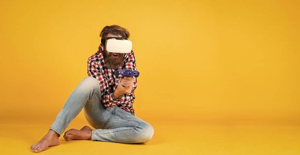 Caucasian mature hipster with trendy hairstyle in checkered shirt playing virtual game in vr glasses, gamer. - 写真・画像