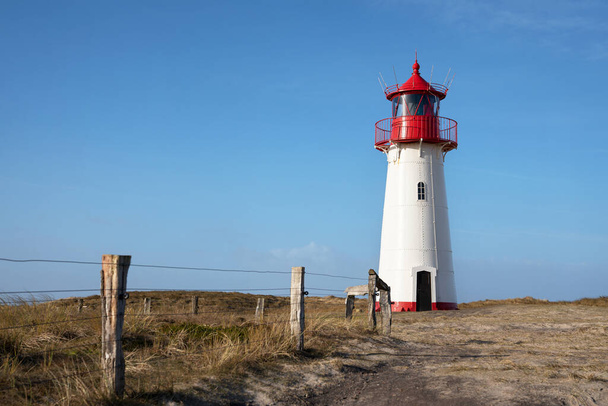 Panoramisch beeld van List West lighthouse against blue sky, Sylt, North Frisia, Duitsland  - Foto, afbeelding