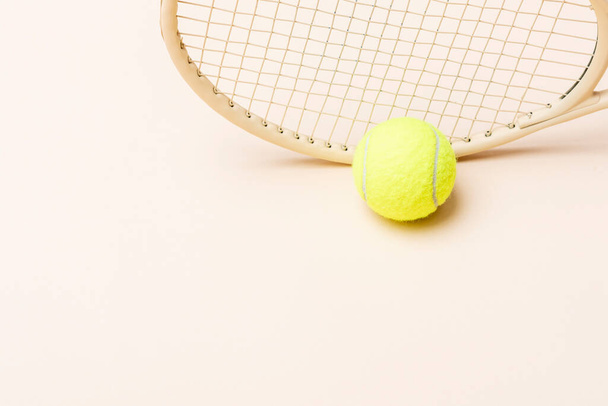 raqueta de tenis beige y bola amarilla sobre fondo beige. Cartel del tema del deporte horizontal, tarjetas de felicitación, encabezados, sitio web y ap - Foto, imagen