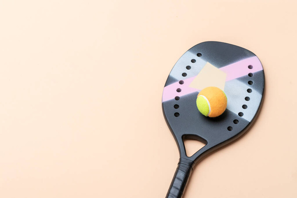 Профессиональная пляжная теннисная ракетка и мяч на бежевом фоне. Горизонтальный плакат спортивной тематики, поздравительные открытки, заголовки, веб-сайт и приложение - Фото, изображение
