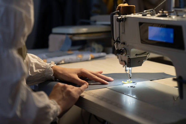 Dámské krejčovské práce na šicím stroji šití vzory nové kolekce. Detailní záběr dámského krejčovství. Švadlena používat profesionální vybavení pro krejčovství. Koncept oděvního průmyslu - Fotografie, Obrázek