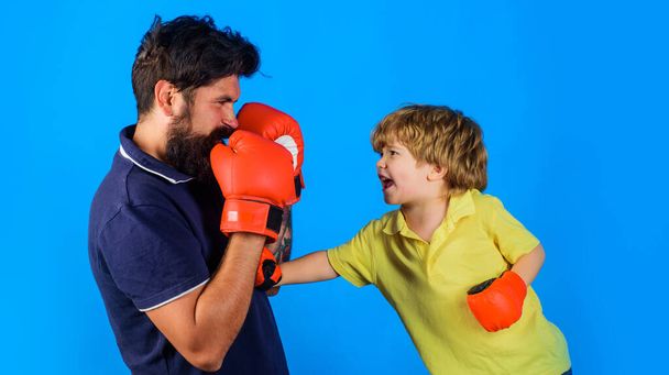 Boksz edző és gyerek tréning. Kesztyűs gyerek bokszolni tanul. Apa és fia harcra készen. - Fotó, kép