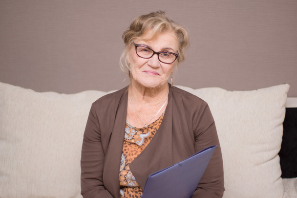 Mulher velha em óculos com uma pasta de mãos dadas
 - Foto, Imagem
