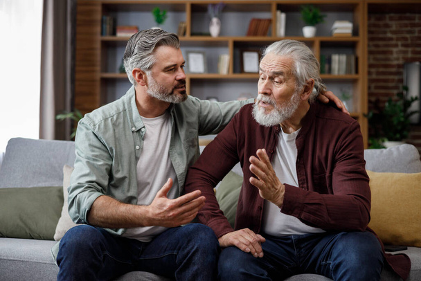 An elderly father complains about life to an adult son, which help him to calm dawn. Two generations family has conversation, sharing news, spending time together. Understanding, care and support. - Photo, Image