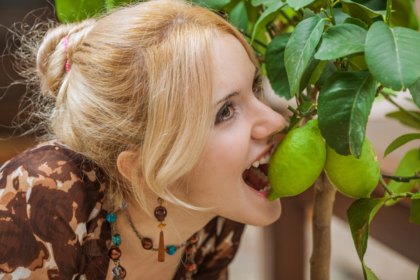 Frau beißt in grüne Zitrone - Foto, Bild