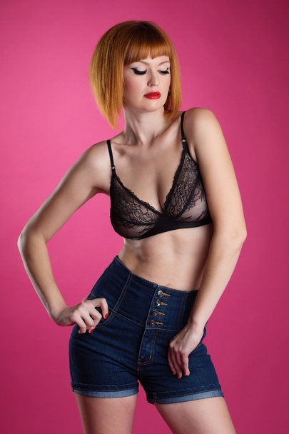 Pretty woman posing in lace bra and denim shorts - Fotoğraf, Görsel