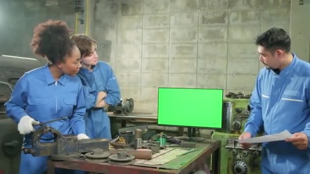 Tres equipos profesionales multirraciales de trabajadores de la industria en uniformes de seguridad trabajos de metalurgia discuten cerca de monitor de pantalla verde, máquinas de torno mecánico y taller en fábrica de fabricación. - Imágenes, Vídeo