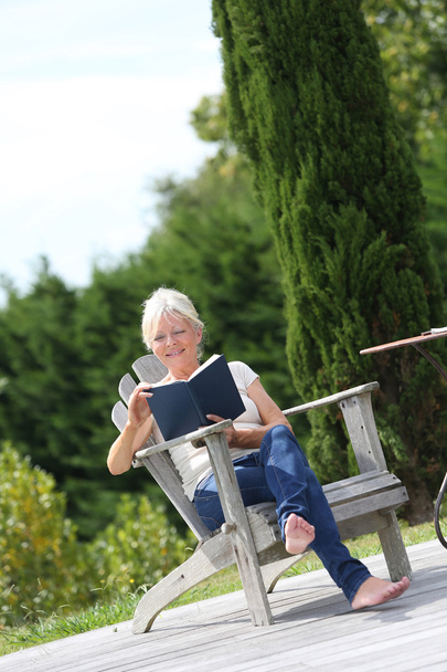 Woman reading book in backyard - Photo, image