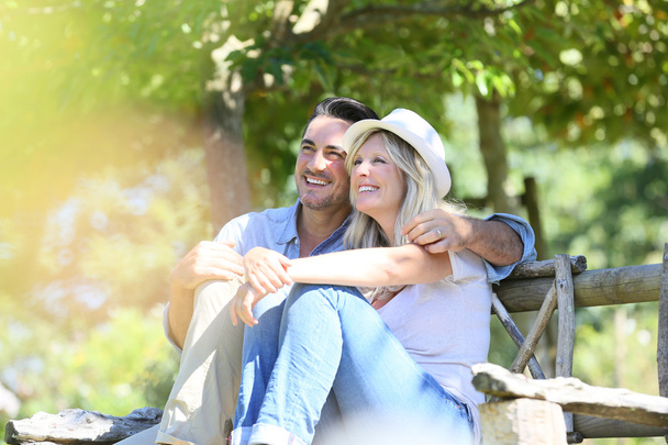 Couple relaxing on wooden bench - Photo, Image