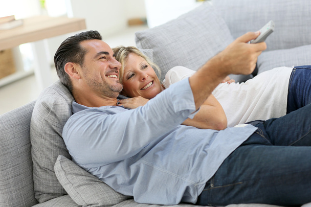 Couple in sofa watching tv - Foto, afbeelding
