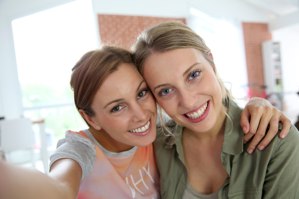Cheerful girlfriends taking picture of themselves - Foto, Imagen