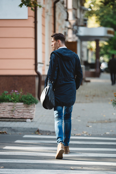 Молодий чоловік переходить вулицю
 - Фото, зображення