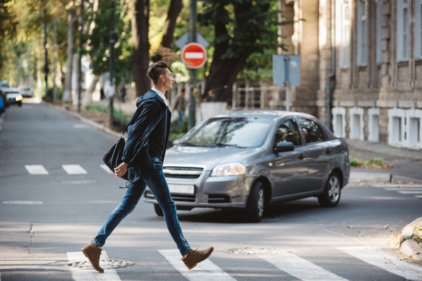 Young man cross the street - Фото, изображение