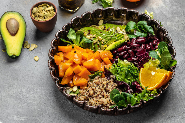 Vegan Salad with quinoa, avocado, sweet potato, beans on dark background. superfood concept. Healthy, clean eating concept. gluten free diet. top view. - Photo, Image