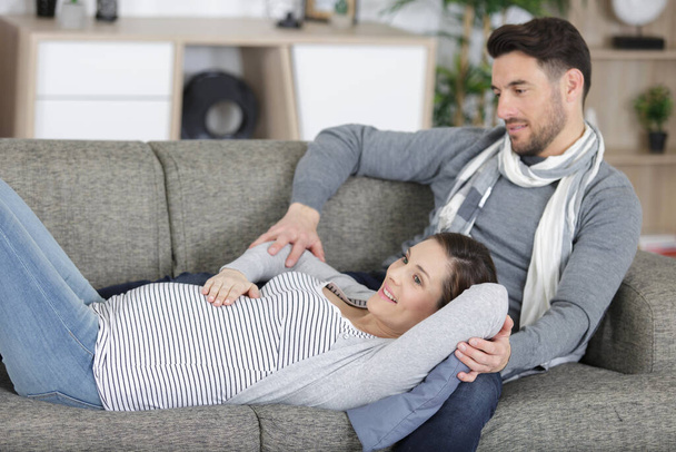 happy pregnant couple relaxing on the sofa - Foto, Imagen