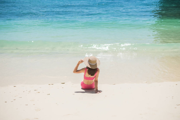 Turista mujer en traje de baño y sombrero rosa, feliz viajero tomando el sol en la playa Paradise en Islas. destinación, wanderlust, Asia Travel, verano tropical, vacaciones y concepto de vacaciones - Foto, Imagen
