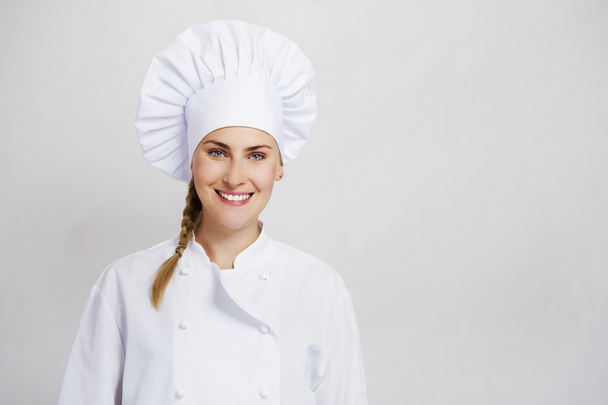 A young, female chef in a traditional hat and coat. - Fotografie, Obrázek