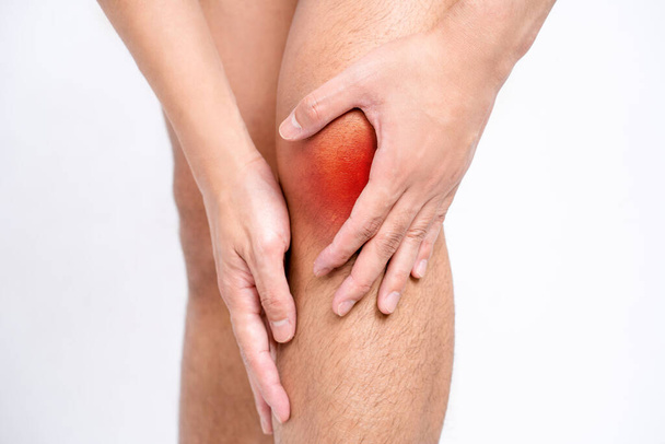 Зблизька азіатські чоловіки з болем у колінах і ногах, використовуючи руки для масажу тіла, щоб полегшити біль, червоні плями з болем.. - Фото, зображення