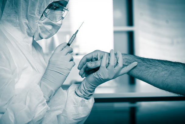 Médico injetando medicação no braço do paciente
 - Foto, Imagem