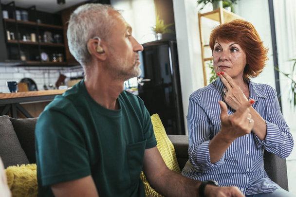 Starší muž mluvit komunikovat se svými přáteli pomocí znakové řeči doma. - Fotografie, Obrázek