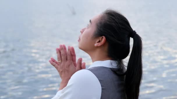 A nő egyedül imádkozik naplementekor. A nők imádkoznak Istenhez, hogy jobb életet kívánjanak. Szellemi és vallási fogalom. - Felvétel, videó