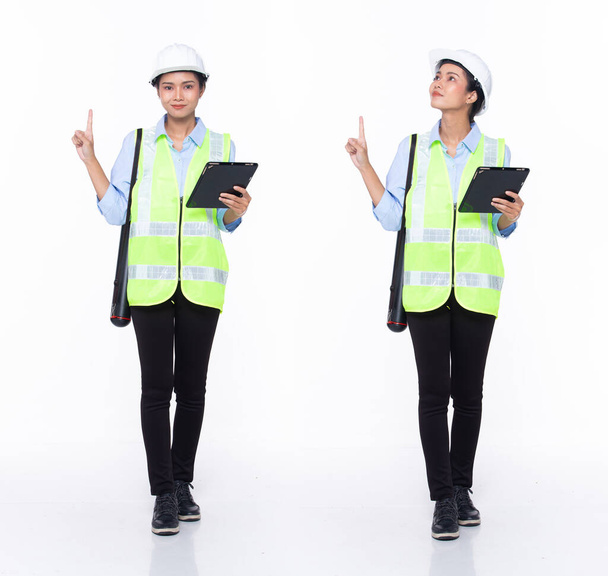 Full length 30s Asian Woman engineer architect business client, pointing finger up in Air, wear safety gear dress. Black hair contractor female feel happy smile wellness over white background isolated - Photo, Image