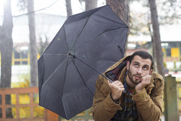 Joven con paraguas preguntándose
 - Foto, Imagen