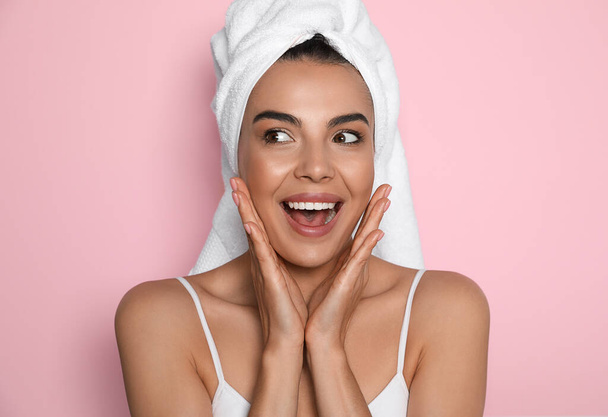 Beautiful young woman with towel on head against pink background - Foto, Imagem