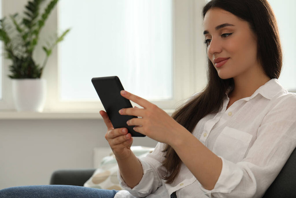 Young woman using e-book reader at home - Foto, Imagen