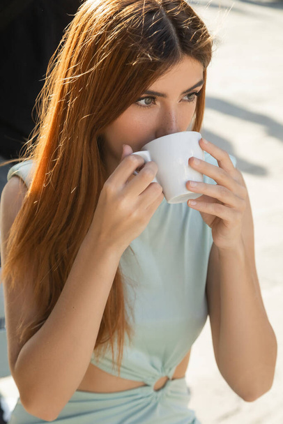 woman with red hair looking away while drinking coffee in Venice - Photo, Image