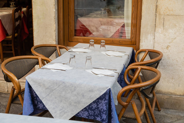chairs near table with cutlery and empty glasses on cafe terrace in Venice - 写真・画像