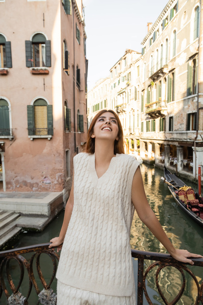 Venedik 'te ortaçağ binalarının yanında dikilen neşeli kadın. - Fotoğraf, Görsel