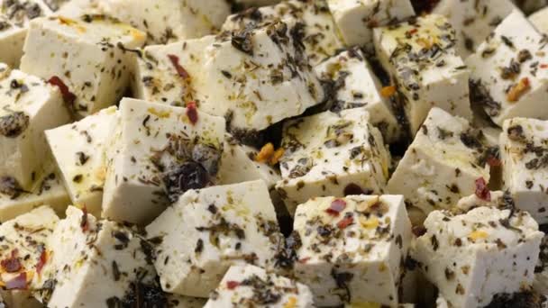 Vegán tofu feta sajt szárított oregánóval, bazsalikommal, kakukkfűvel és fokhagymával. Forgó videó. - Felvétel, videó