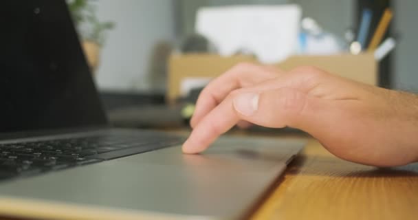 Mans clics mano en el ordenador portátil touchpad, primer plano, vista lateral, deslizar el dedo sobre la superficie. Trabajando con computadora, escritorio. El concepto de tecnología informática, trabajo remoto, trabajo en casa, navegar por la red - Metraje, vídeo