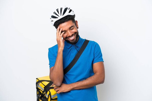 Mladý brazilský muž s termální batoh izolované na bílém pozadí se směje - Fotografie, Obrázek