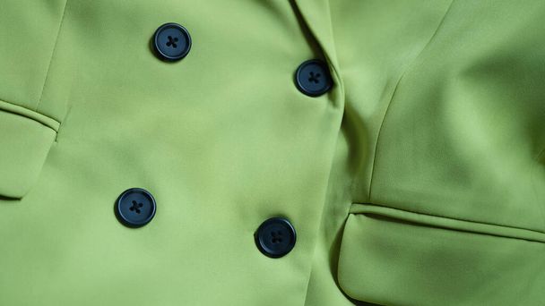 Hellgrüne Jackenbluse mit schwarzen Knöpfen. Stilvolle Trendfarbe im Kleidungskonzept - Foto, Bild
