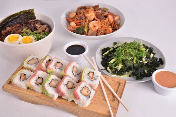 Μια ποικιλία από διάφορα ιαπωνικά τρόφιμα - ρολά, ράμεν, σαλάτα Wakame, γαρίδες - Φωτογραφία, εικόνα