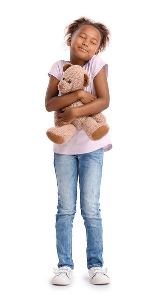 Little African-American girl with teddy bear on white background - Foto, Imagem
