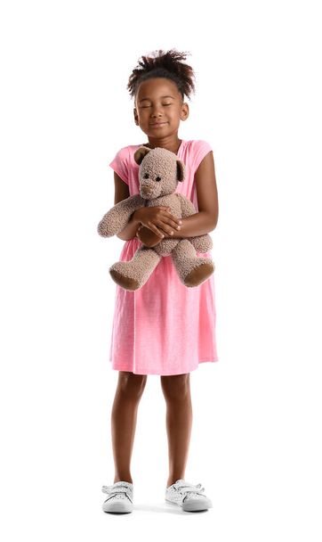 Маленька афро-американська дівчина з плюшевим ведмедиком на білому фоні - Фото, зображення