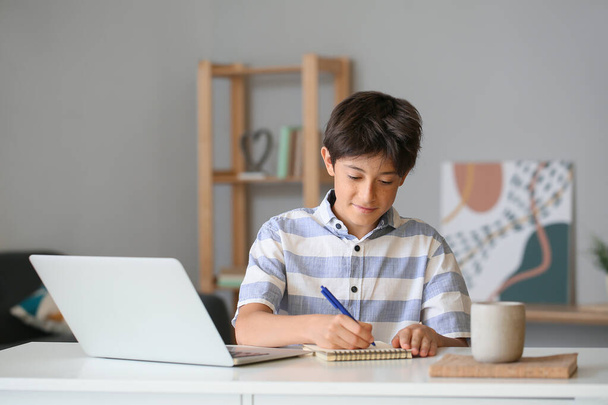 Хлопчик-підліток пише в блокноті вдома
 - Фото, зображення