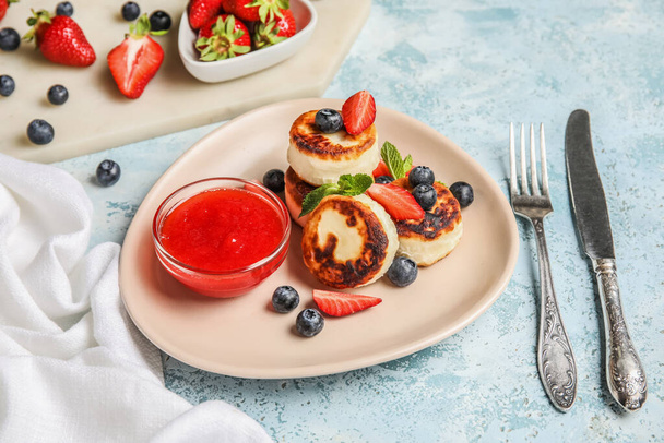 Piatto con pancake di ricotta, bacche e marmellata di fragole su sfondo blu - Foto, immagini