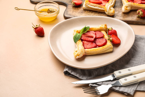 Πιάτο με λαχταριστή σφολιάτα φράουλα σε μπεζ τραπέζι - Φωτογραφία, εικόνα