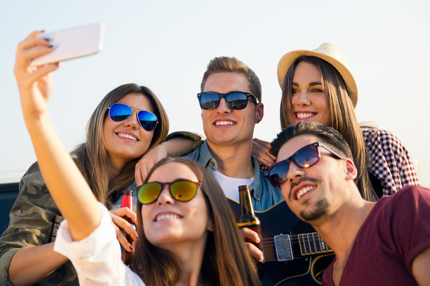 Group of friends taking a selfie with smartphone. - Zdjęcie, obraz