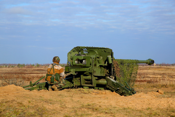 Gunner perto de canhão
 - Foto, Imagem
