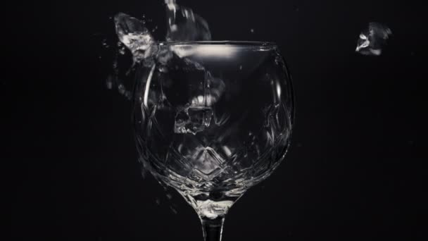 Led kostky citróny padá prázdné sklenice detailní up. Zmrazené bloky máta a limetky házet na průhledné sklo v super zpomaleném filmu. Vytváření černého pozadí makra. Koncept osvěžujícího nápoje - Záběry, video
