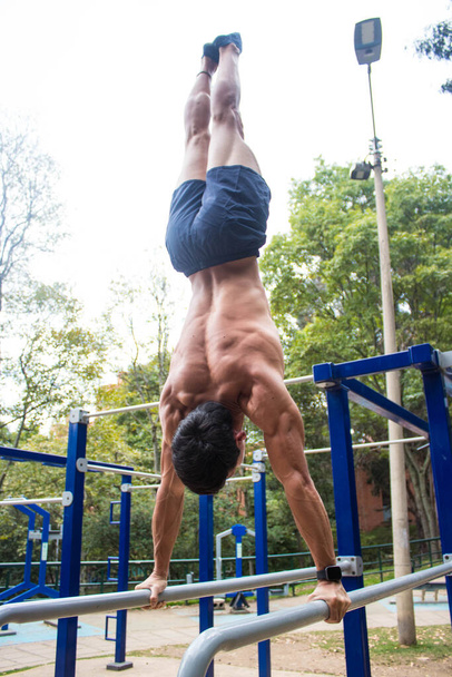 A young shirtless athletic man exercising in a park - Fotografie, Obrázek