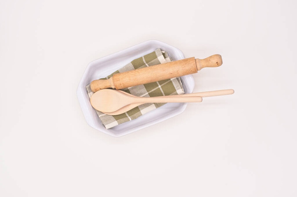 wooden kitchenware in a white ceramic casserole with table napkin view from above - Foto, Bild