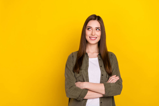 Photo of cute cheerful businesswoman look blank space with folded arms brainstorming isolated on yellow color background. - Zdjęcie, obraz